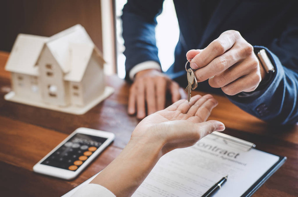 Real estate agent Sales manager holding filing keys to customer after signing rental lease contract of sale purchase agreement, concerning mortgage loan offer for and house insurance. - Foto, Imagem