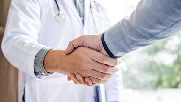 Medicine and health care concept, Professional Male doctor in white coat handshake with patient after successful recommend treatment methods. - Φωτογραφία, εικόνα