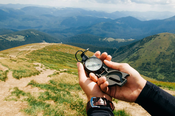 ein Wanderer in den Bergen mit einem Kompass in der Hand. - Foto, Bild