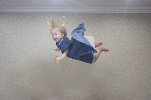 falling concept. a little girl is talking on the ceiling. the child falls from a height - Foto, immagini