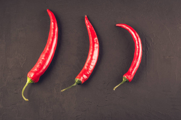 composition of chili pepper/red hot Chile pepper on a dark stone background. Top view - Valokuva, kuva