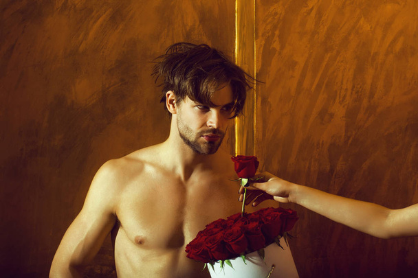 bearded muscular man with sexy body holds red rose box - 写真・画像