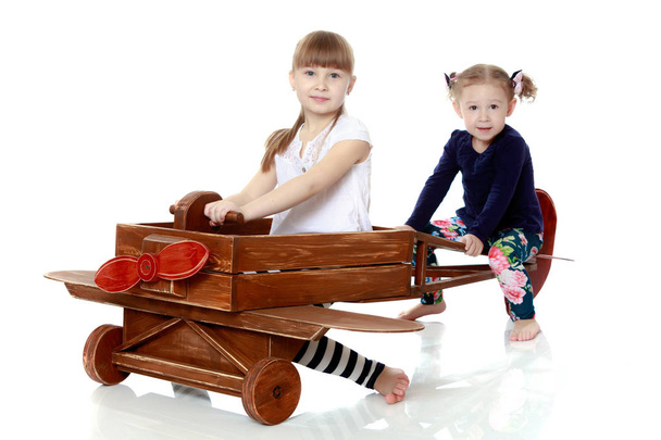 two sisters playing in a wooden plane - Фото, зображення