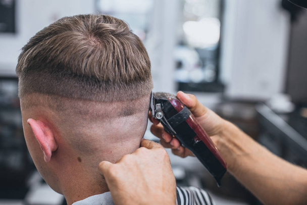 Haircut men Barbershop. Men's Hairdressers barbers. Barber cuts the client machine for haircuts. - Zdjęcie, obraz