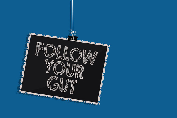 Writing note showing Follow Your Gut. Business photo showcasing Listen to intuition feelings emotions conscious perception Hanging blackboard message communication information blue background - Photo, Image