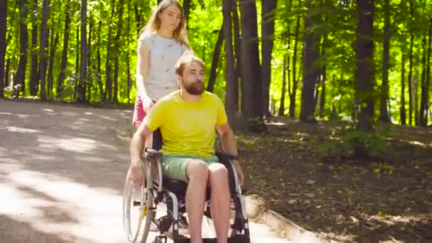 Young disable man on a walk in the park with his wife - Footage, Video