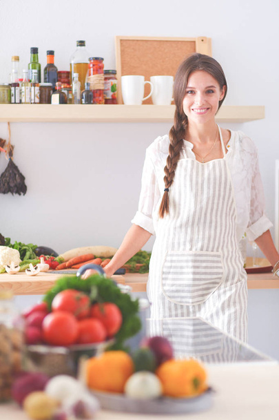Young woman standing near desk in the kitchen. Young woman . - 写真・画像