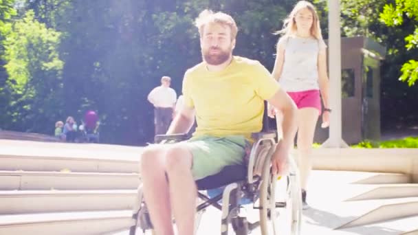 Behinderter Mann im Rollstuhl fährt die schiefe Ebene hinunter - Filmmaterial, Video