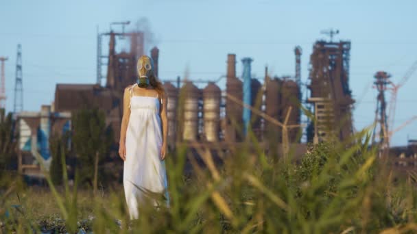 Bir arka planda bir fabrikanın dumanlı boru gaz maskeli kadın - Video, Çekim