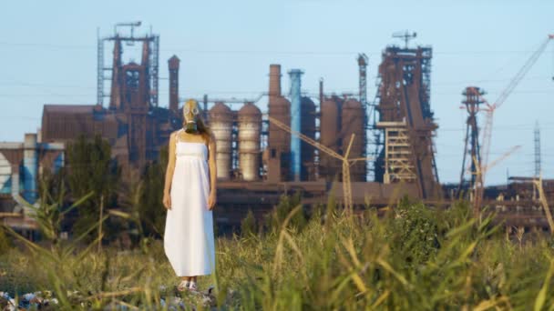 Mujer en una máscara de gas sobre un fondo de pipas humeantes de una fábrica
 - Metraje, vídeo
