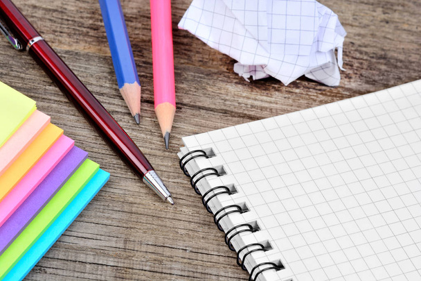 Κοντινό πλάνο του σημειωματάριο με στυλό και πολύχρωμο σημειώσεις στο γραφείο - Φωτογραφία, εικόνα