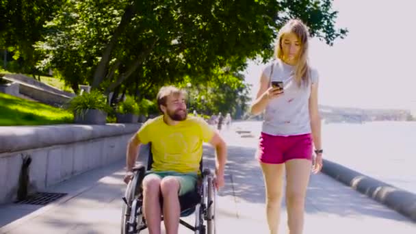 Junger behinderter Mann spaziert mit seiner Frau am Fluss - Filmmaterial, Video