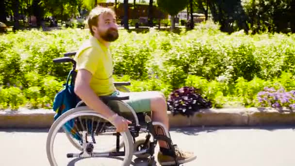 Νέοι απενεργοποιήσετε άνδρα σε αναπηρικό καροτσάκι στο πάρκο - Πλάνα, βίντεο