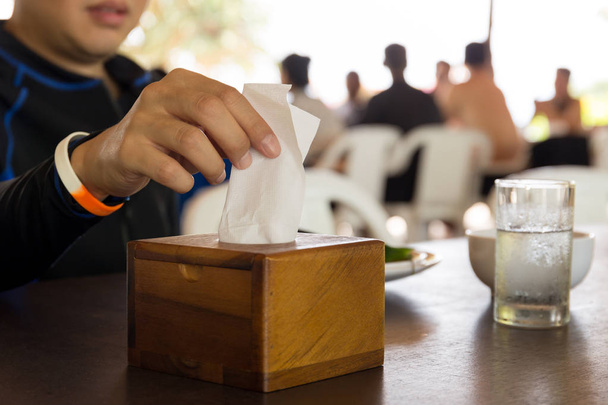 Hand picking white tissue paper from tissue box at lunch time. - Photo, Image