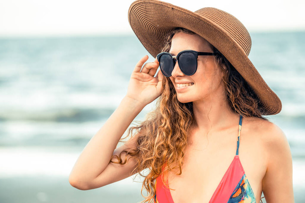 Mujer joven feliz con traje de baño que pasa un buen rato en la playa tropical en verano para vacaciones de viaje
. - Foto, imagen