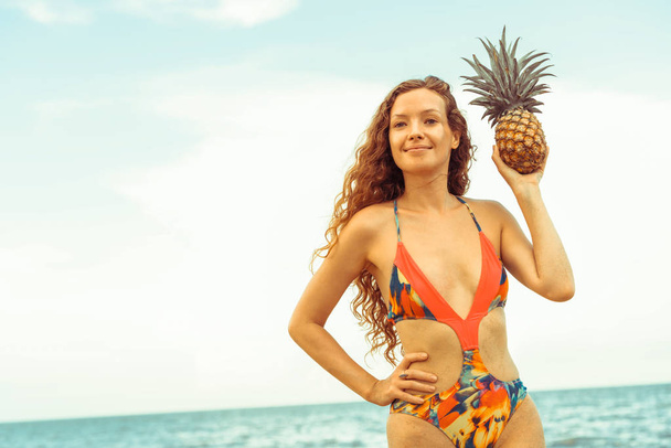 Onnellinen nuori nainen yllään uimapuku trooppisella hiekkarannalla kesällä lomamatkaa varten
. - Valokuva, kuva