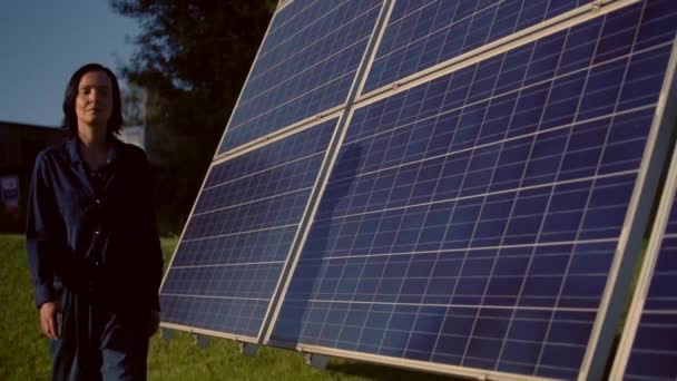 Frau im blauen Kittel läuft über Solarbatteriefeld - Filmmaterial, Video