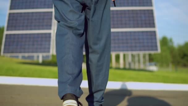 pracovník na sobě modré džínové chůzi k baterii solarcell - Záběry, video