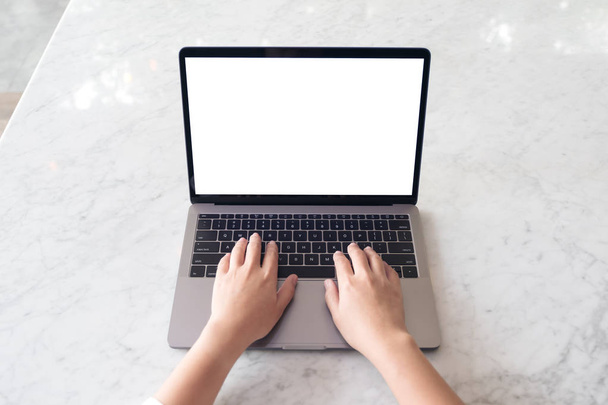 Draufsicht Attrappe der Hände mit und Eingabe auf Laptop mit leerem weißen Desktop-Bildschirm auf Marmortisch im Café - Foto, Bild