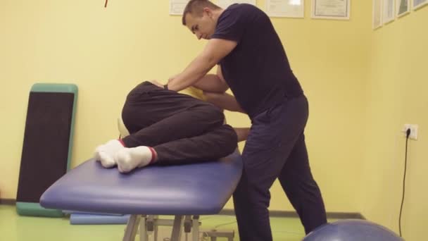 Lékař pomáhá sportovec v rehabilitačním centru - Záběry, video