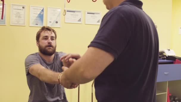 Doctor ayudando a deportista en el centro de rehabilitación
 - Imágenes, Vídeo