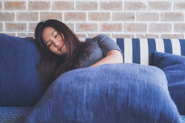 Изображение азиатской женщины, спящей на диване с чувством расслабленности и комфорта
 - Фото, изображение
