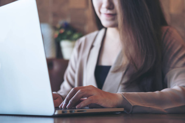 Imagem de close-up de uma bela mulher de negócios asiática olhando, trabalhando e digitando no teclado do laptop no escritório
 - Foto, Imagem