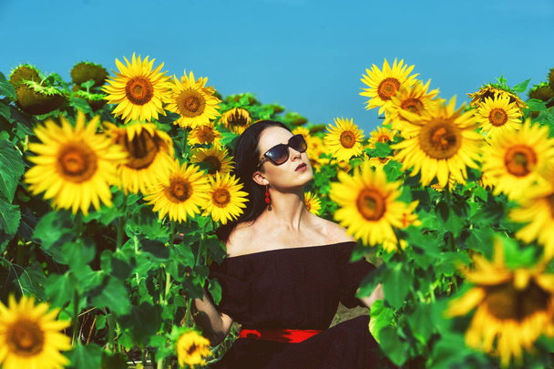 Portrait of a young woman in sunflowers .Romantic girl in the field with sunflowers - Foto, Imagen