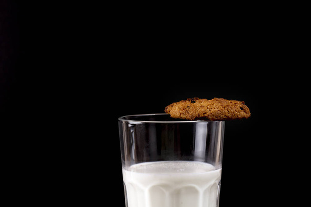 The cookie on the edge of a glass of milk. - Fotoğraf, Görsel