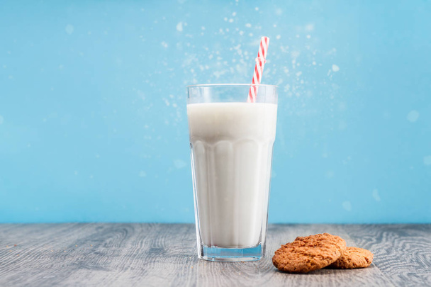 Healthy milk in glass and cookies on the table and on the blue background - Foto, imagen