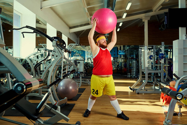 A funny fat man  doing exercises in the gym. - Fotoğraf, Görsel