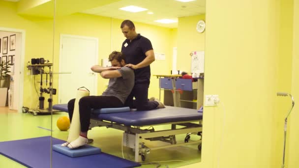 Lékař pomáhá mladý muž v rehabilitačním centru - Záběry, video