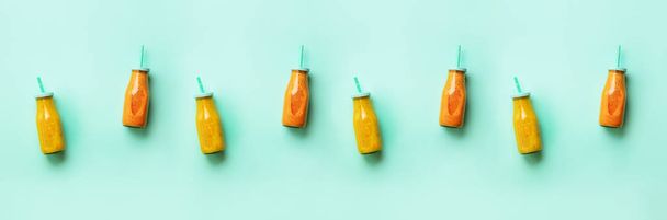 Fresh orange, banana, pineapple, mango smoothies and juicy fruits on blue background. Banner. Seamless pattern. Detox summer drink. Vegetarian concept. Top view, flat lay, copy space. - 写真・画像