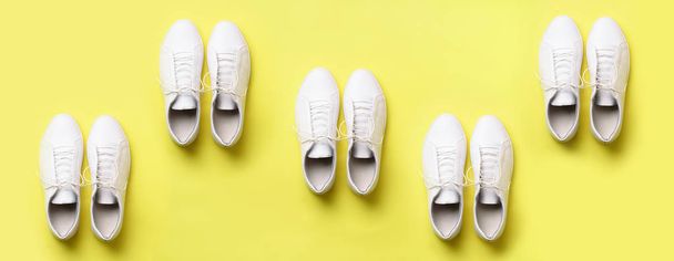 Stylish white sneakers and rope on yellow background with copy space. Top view. Minimal flat lay. Summer shoes collection. First step concept. - Foto, Imagem