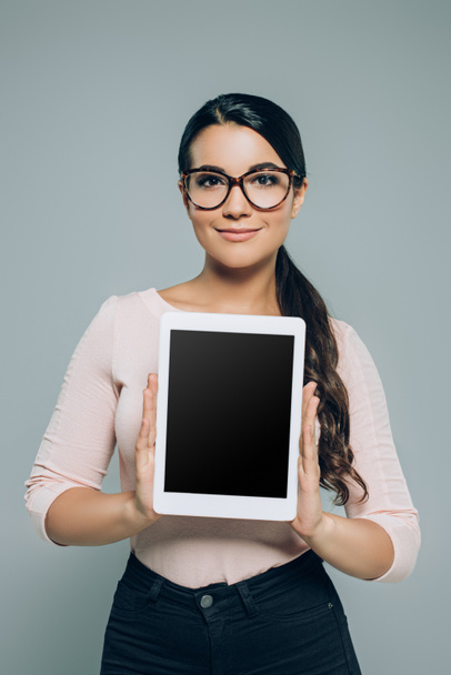 woman showing digital tablet with blank screen, isolated on grey - Foto, imagen
