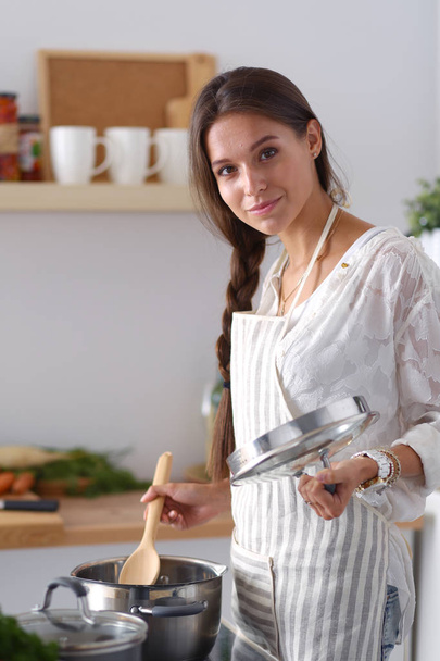 Cooking woman in kitchen with wooden spoon. Cooking woman - Фото, изображение