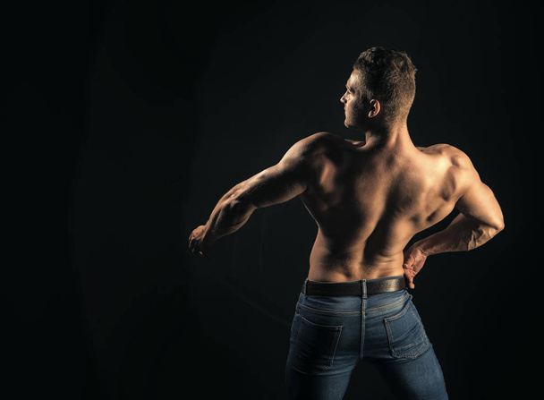 Athlete man with bare torso in blue jeans, back view - Fotografie, Obrázek