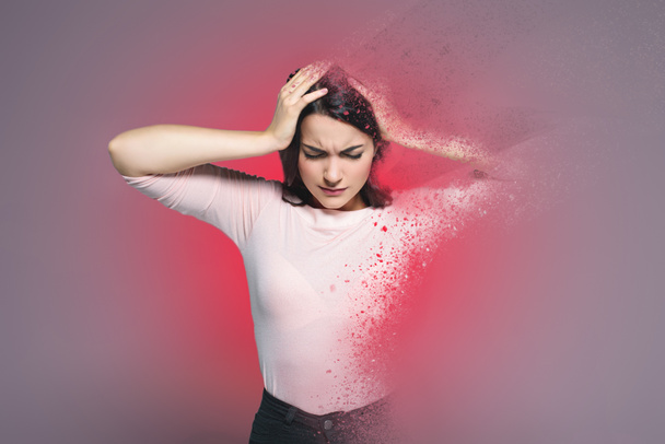 beautiful woman suffering from headache, with red splatter around - Photo, Image