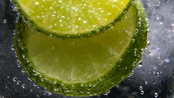 Detox or thirst concept. Healthy, dietary nutrition. Cold lemonade, lime drink. Black background - Footage, Video