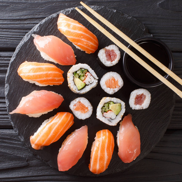 素朴な暗い背景に日本の寿司。巻き寿司、握り寿司、マキ、醤油寿司のテーブルにセットします。背景。アジアン料理。abov から平面図 - 写真・画像