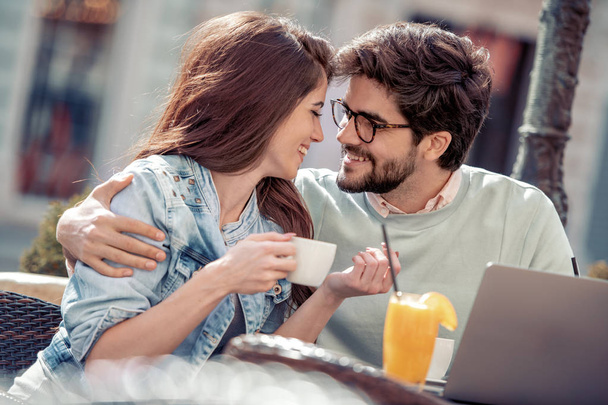 Пара сидить у кафе та використовує ноутбук, п'є каву та апельсиновий сік
.  - Фото, зображення