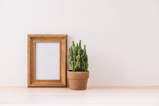 marco simulado con maceta de cactus en suelo de madera
 - Foto, Imagen