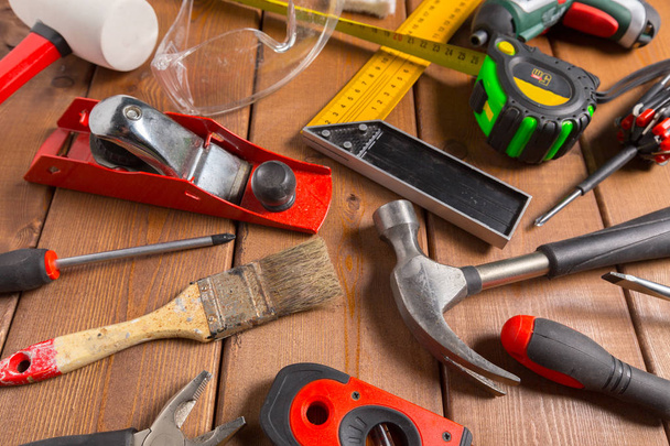 Assorted work tools on wood background - Фото, изображение