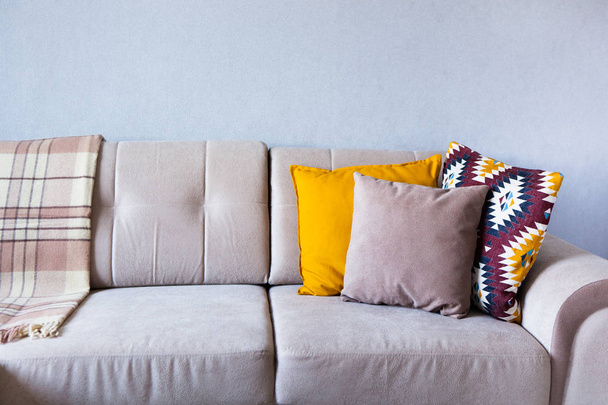 Coussins et plaid sur le canapé beige fermer avec de l'espace de copie. Doux foyer et concept cosy. À l'intérieur
 - Photo, image