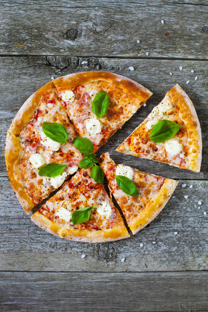 Homemade hot pizza with tomatoes, mozzarella and basil. Top view with copy space on wooden table. - Foto, Imagen