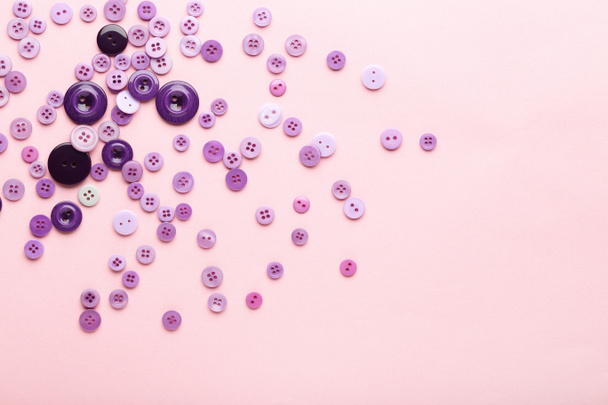 Purple sewing buttons on pink background - Fotoğraf, Görsel