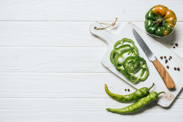 top view of chili and bell peppers on white wooden table - Foto, afbeelding