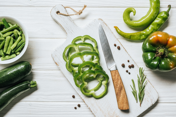 top view of cut green bell pepper on white wooden cutting board - Fotografie, Obrázek