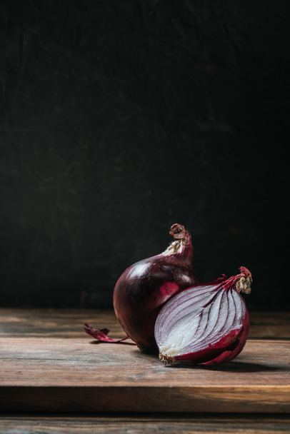 ripe cut red onion on cutting board isolated on black - Photo, Image