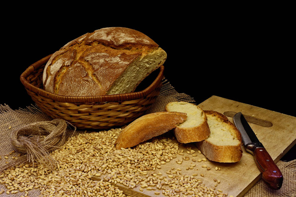 Ahsap zemin uzerinde cesitli ekmekler, kase icerisinde bugday ve cevizler - Fotó, kép